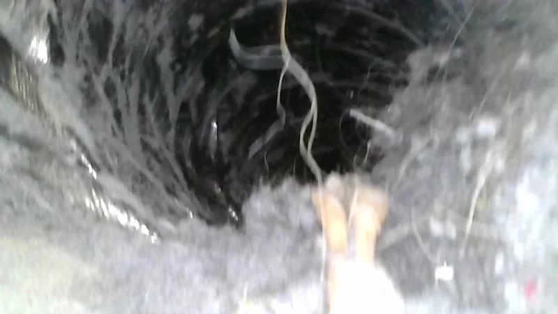 Inside a dryer duct packed with dark matted lint and debris